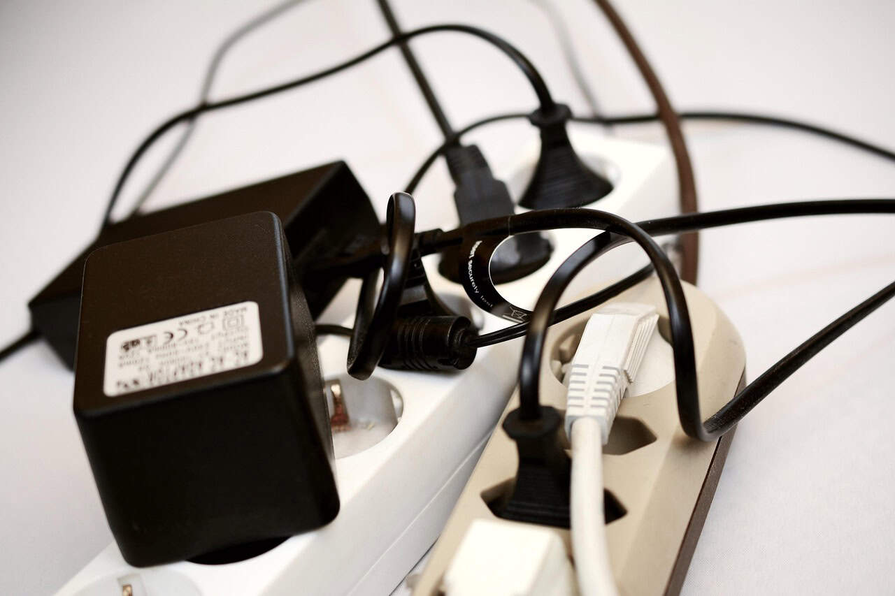 Electrical cords and chargers plugged into two surge protectors