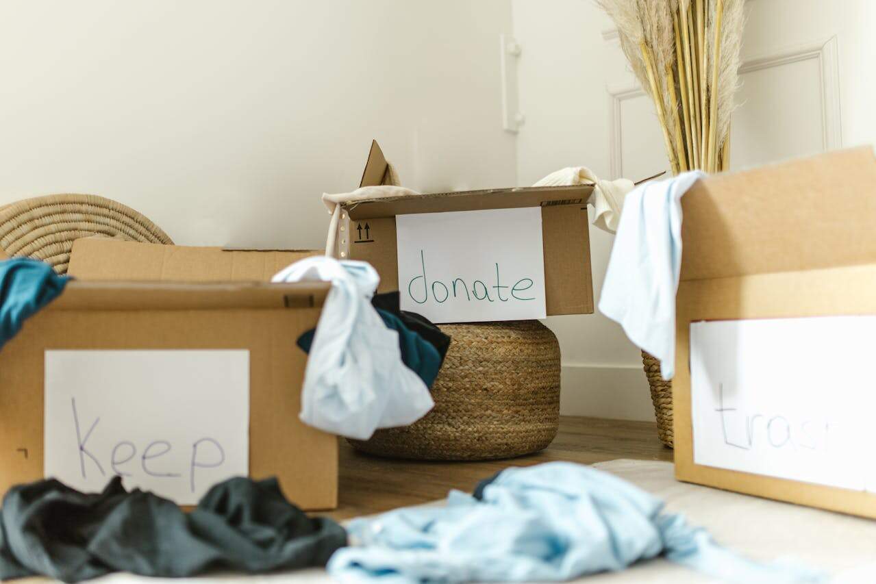 Three boxes labelled 'Keep', 'Trash', and 'Donate', with clothes around them