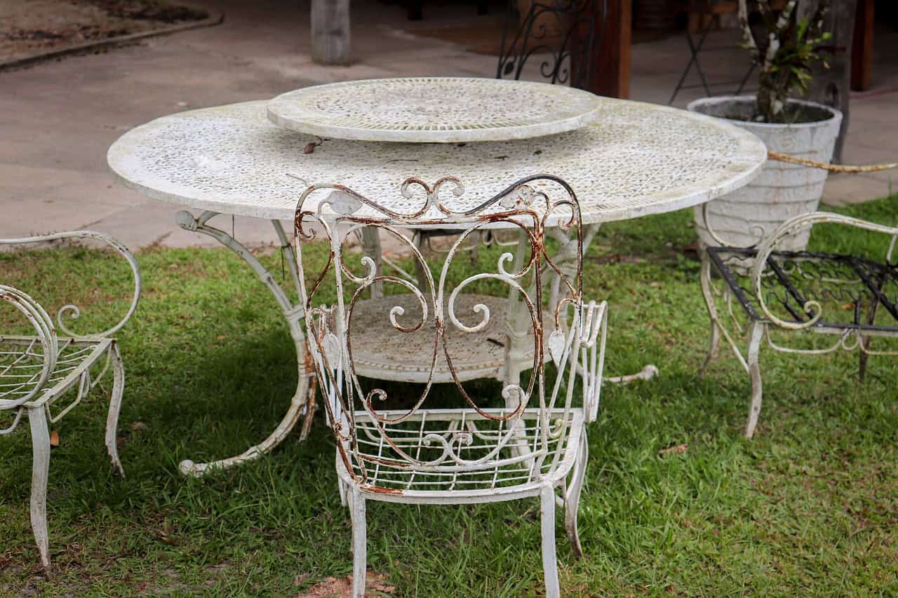 Rusting old garden furniture that consists of a table and three chairs